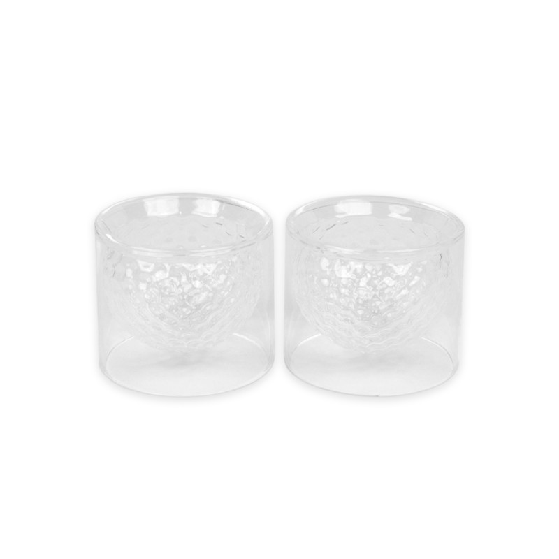 Dale un giro original a tus bebidas con este set de dos vasos inspirados en pelotas de golf. Fabricados en vidrio de doble pared